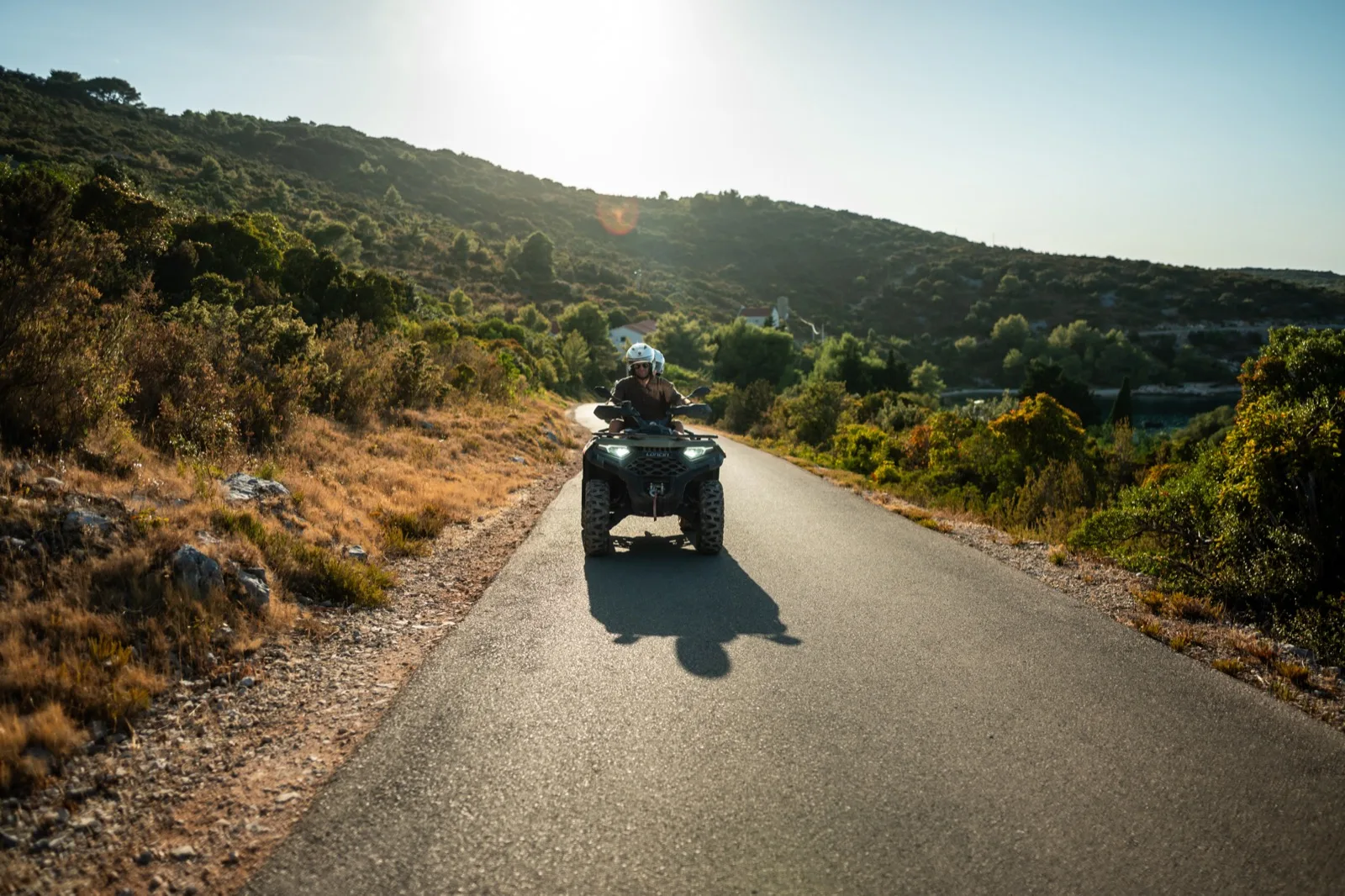 A quad bike on a quiet coastal road at sunset, on an excursion ashore