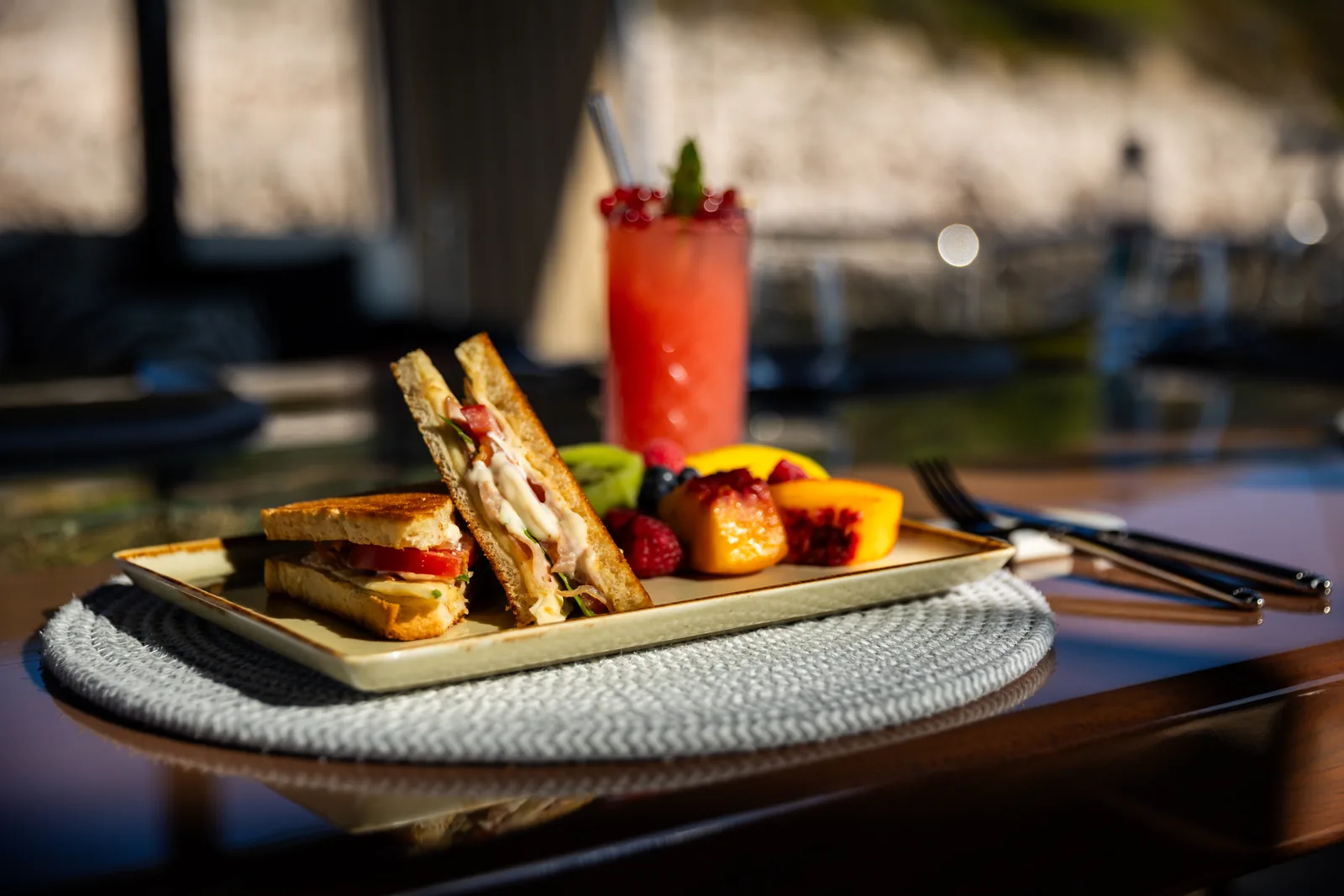 Grilled sandwiches with fruit and a fresh cocktail, served on deck