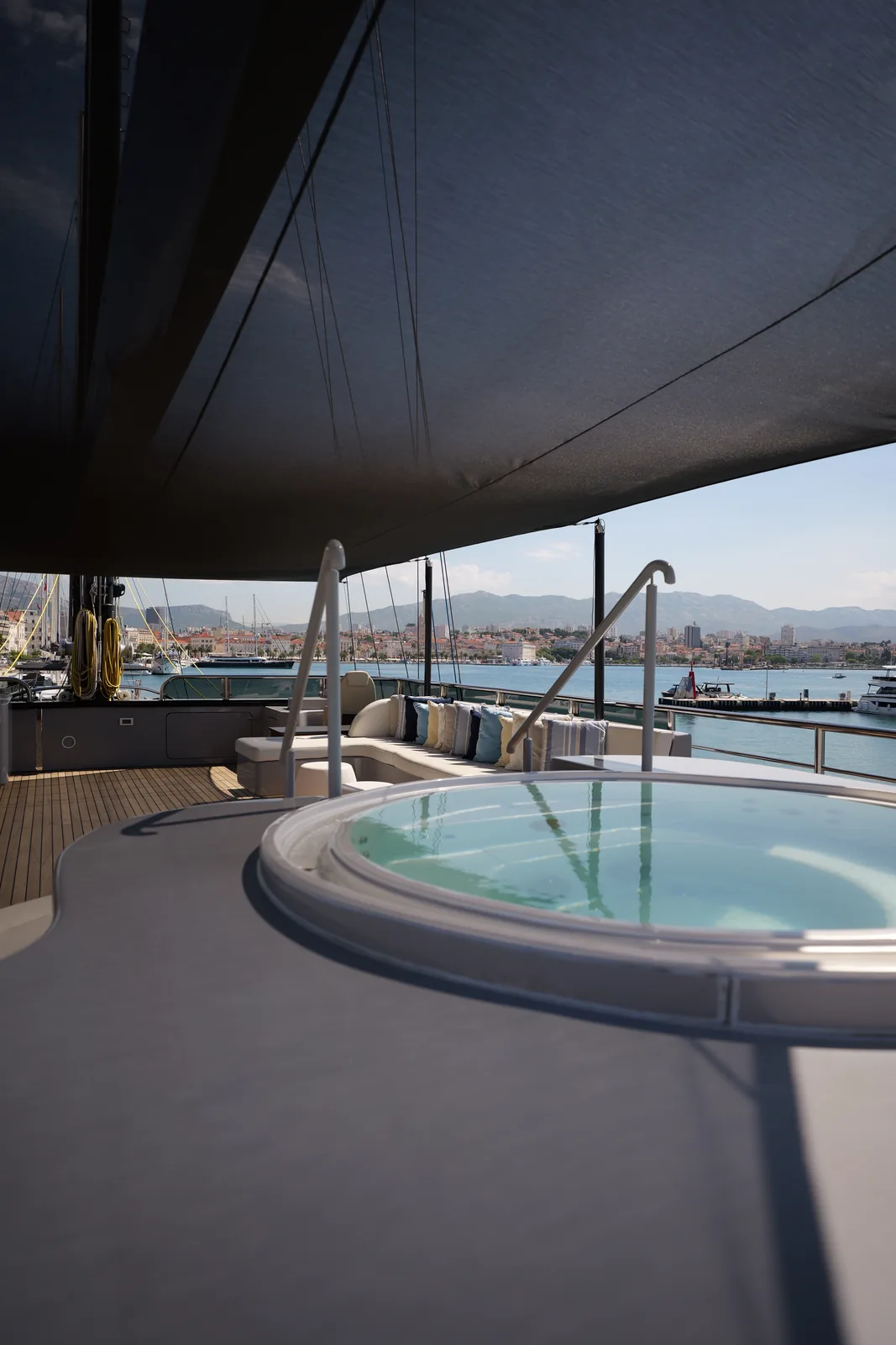 The sundeck jacuzzi of S/Y Rara Avis, with the harbour beyond