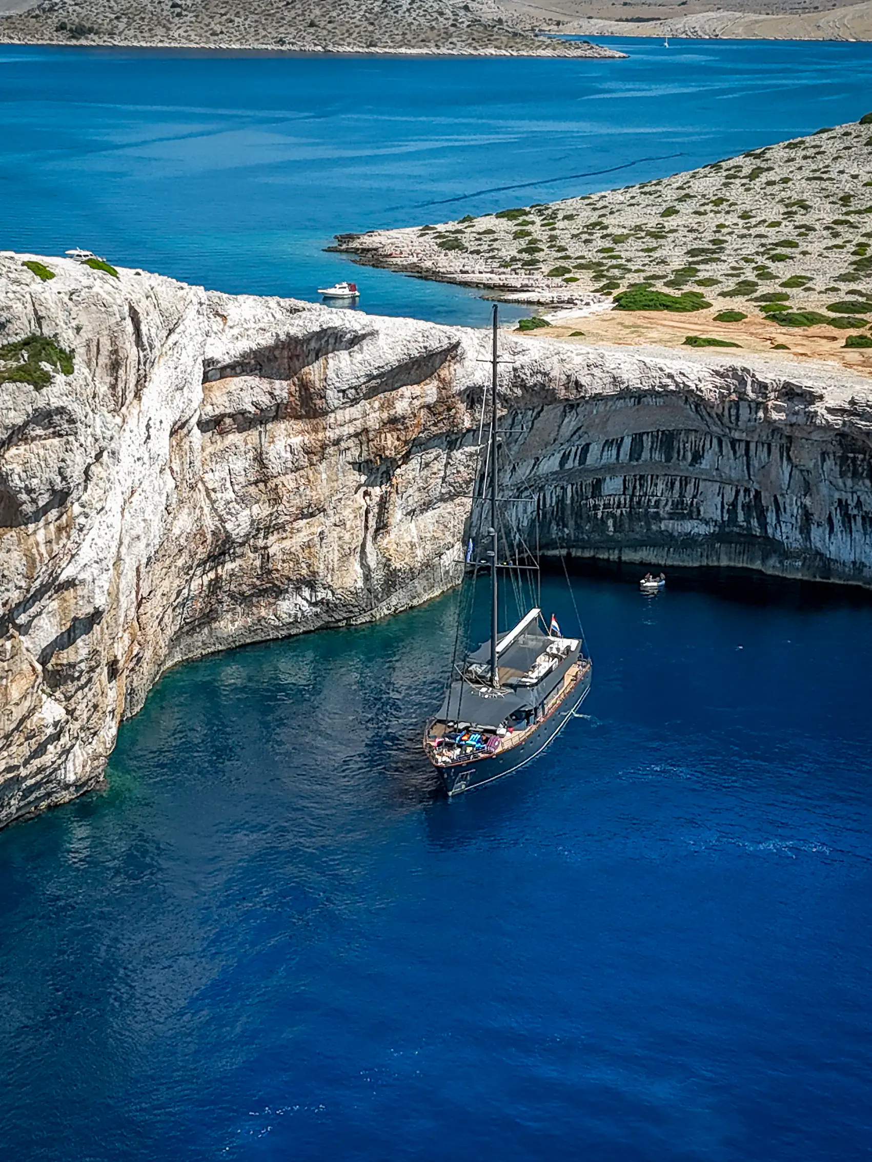 S/Y Rara Avis anchored beneath the limestone cliffs of a Kornati cove